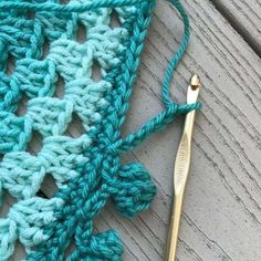 the crochet is being worked on with a pair of gold scissors next to it