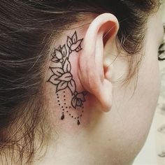 a woman's ear with a flower tattoo on it