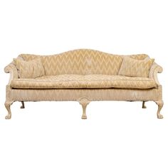 an old fashioned couch with two pillows on it's back and armrests