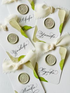 six wedding tags with white ribbons and green leaves