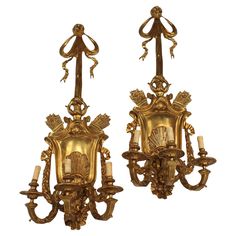 two golden wall sconces with candles attached to them