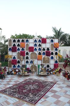 an elaborately decorated area with many vases and flowers on the wall, in front of a tiled floor