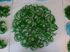 several pieces of green glass sitting on top of a white tile floor next to each other