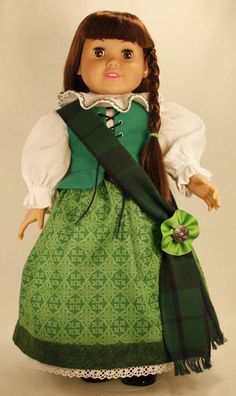 a doll with long hair wearing a green dress and holding a scarf in her hand