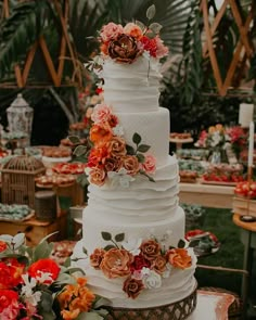 a tall white wedding cake with flowers on top