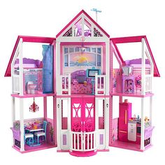 a pink doll house with furniture and accessories