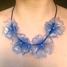 a woman wearing a blue necklace with flowers on it