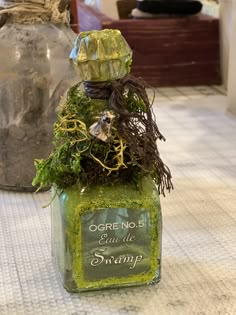 a bottle filled with moss sitting on top of a table