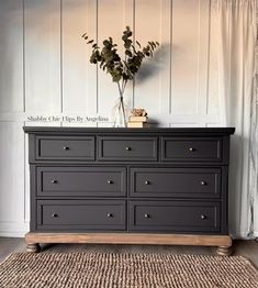 a black dresser sitting in front of a white wall