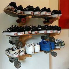 several pairs of shoes and skateboards are hanging on the wall above a pair of roller skates