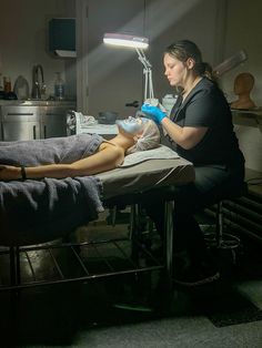 a woman is getting her leg examined by a medical professional in a hospital room at night