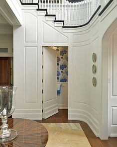 an entry way leading to a foyer with white walls and wood flooring on the other side