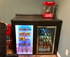 a mini fridge with drinks and sodas in it sitting on top of a table