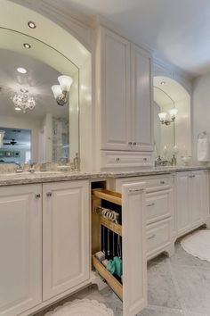 a large bathroom with white cabinets and marble counter tops