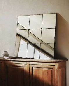 a mirror sitting on top of a wooden dresser