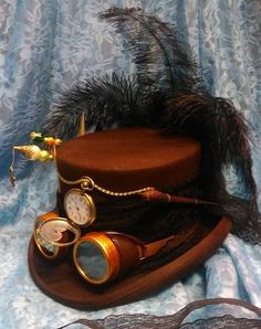 Gorgeous handcrafted fully lined Steampunk Victorian 100% brown wool top hat. Brown & gold goggles are around center of hat with clock wheels inside one lense along with black lace ribbon which is tied into bow at back then trails down. Black lace is also around middle of hat & 3 tall black feathers are at back. Beige, orange, red & brown rooster feathers are at side along with 2 x hatpins adorning pearls, beads & a lock brass charm. A gold satin ribbon bow is under hatpins & A vintage dip pen s Vintage High Crown Costume Hats For Cosplay, Steampunk Brown Adjustable Hat, Vintage Short Brim Costume Hats For Themed Events, Steampunk Brimmed Costume Accessories For Party, Steampunk Costume Accessories With Brimmed Shape, Steampunk Brimmed Costume Accessories For Costume Party, Steampunk Brimmed Costume Hat For Cosplay, Vintage Brown Costume Hats And Headpieces For Festival, Vintage High Crown Costume Hats For Themed Events