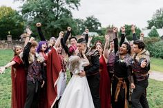 a group of people dressed in medieval clothing posing for a photo with their arms up