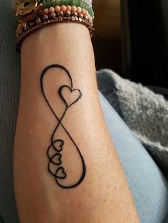 a tattoo on someone's arm that has an infinite love symbol in the shape of a heart