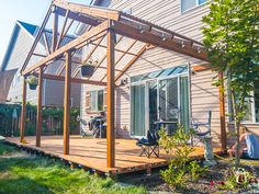 a person sitting on a wooden deck in front of a house with an attached patio