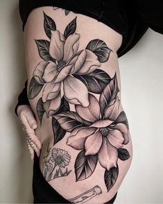 a pregnant woman's stomach with flowers and leaves tattooed on the bottom part of her belly