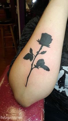 a black rose tattoo on the left arm