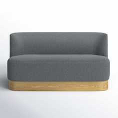 a gray couch sitting on top of a wooden base