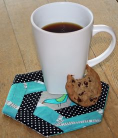 a cup of coffee and a cookie on a table