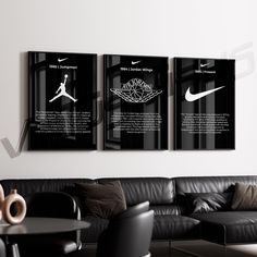 three black and white posters hanging on the wall above a leather couch in a living room