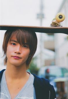 a young man holding a skateboard over his head