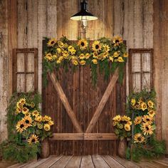 an old barn with sunflowers and greenery on the front door to it