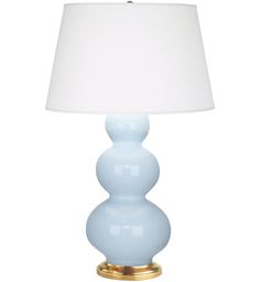 a light blue lamp with a white shade on it's side and a gold base