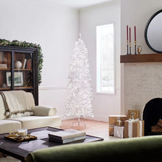 a living room with a white christmas tree in the corner and presents on the coffee table