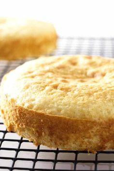 a cake sitting on top of a cooling rack next to another piece of cake in the background