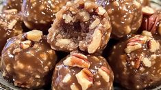 chocolate covered candies with pecans and walnuts on top, in a bowl