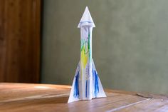 a paper rocket sitting on top of a wooden table