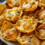 a white plate topped with cheesy crackers covered in cheese