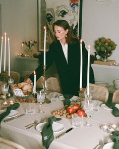 a woman sitting at a table with candles in front of her