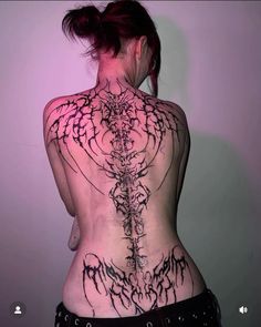 the back of a woman's body with tattoos on her chest and lower back