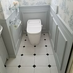 a white toilet sitting inside of a bathroom next to a sink