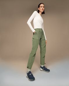 a woman in white shirt and green pants