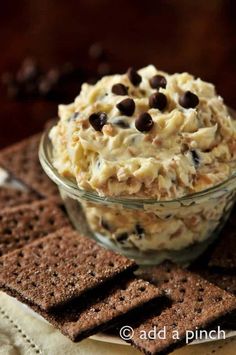 a bowl filled with food sitting on top of a table next to crackers and chocolate chips