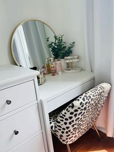 a white desk with a leopard print chair next to it and a mirror on the wall