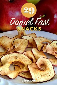 an apple and some chips on a white plate with the title 29 daniel fast snacks