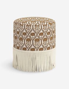 a brown and white ottoman with fringes