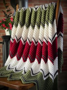 a blanket is draped on a chair next to a brick wall and potted plant