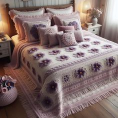 a bed with purple flowers on it in a bedroom