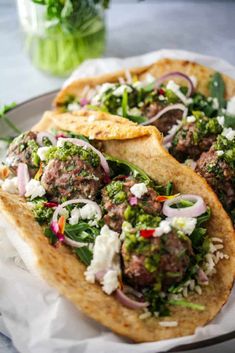 two pita breads with meat and veggies on them sitting on a plate