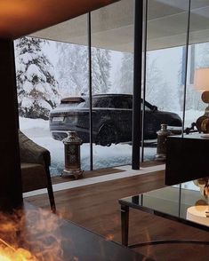 a living room filled with furniture and a fire place next to a large glass window