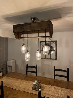 a wooden table with four lights hanging from it