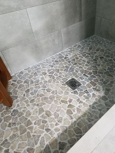 a tiled shower with a drain in the middle